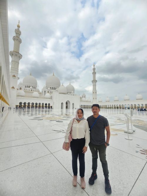 Sheikh Zayed Grand Mosque Courtyard, Grand Mosque Exterior at Sunset, Chandelier in the Main Prayer Hall, World's Largest Hand-Knotted Carpet, Intricate Column Design, Reflective Pools at Night, Visitors in the Mosque's Courtyard, Guided Tour in Progress, Aerial View of the Mosque, Women in Traditional Abayas